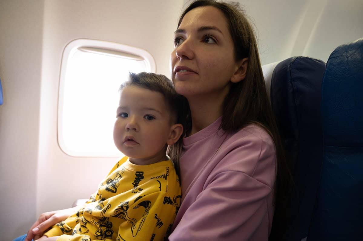 Mother onboard aeroplane with child